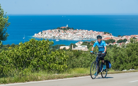 Cyclists in front of the Primosten peninsula in Croatia