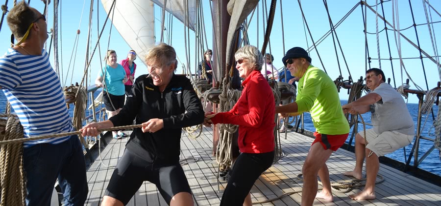 Tour group hoists the sails on the tall ship Atlantis