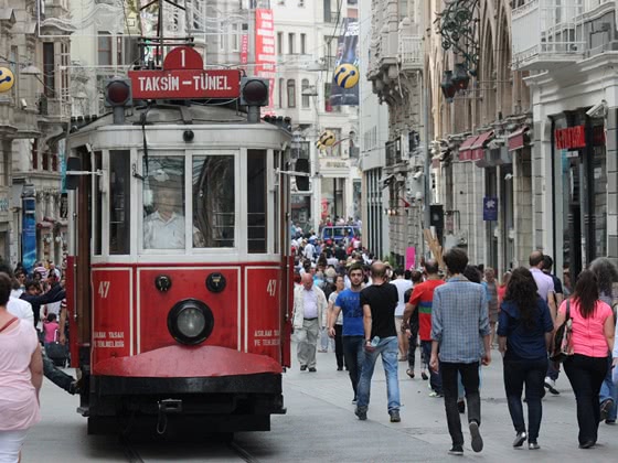 Red tram driving along a busy street in Istanbul