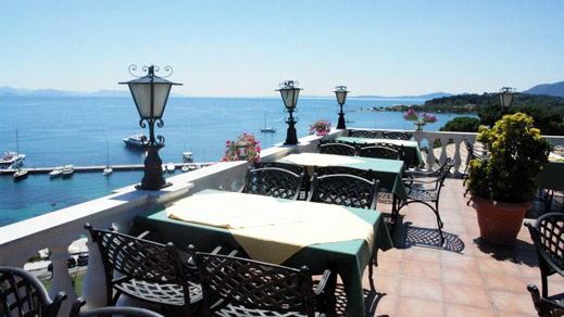 Hotelterrasse mit Tischen und Stühlen, mit Blick auf das Meer