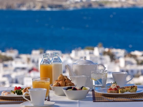 Gedeckter Frühstückstisch mit Stadt und Meer im Hintergrund