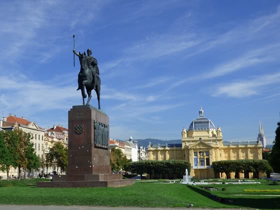 Platz in Zagreb mit Statue und großem gelben Gebäude
