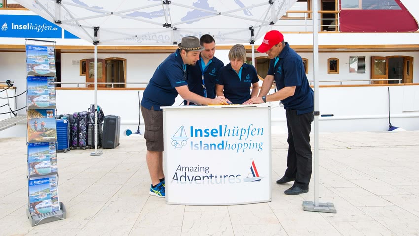 Four Islandhopping guides standing at desk outside