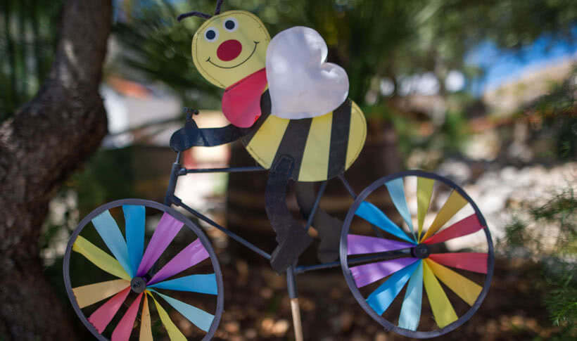 Bildhauerei: Biene auf Fahrrad mit regenbogenfarbenen Rädern